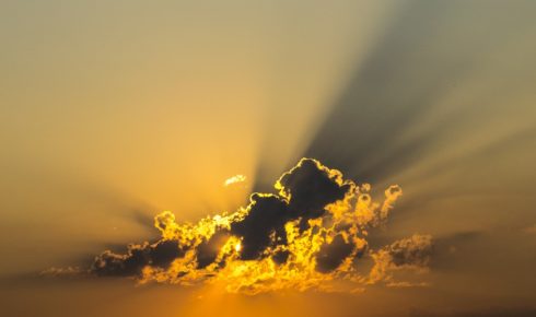 photo of a cloud in the sky with the sun behind it